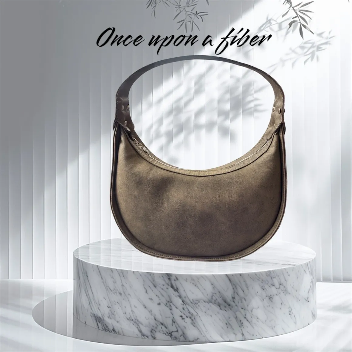 Brown crescent handbag on marble.