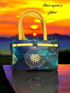 Celestial handbag with yellow handles.