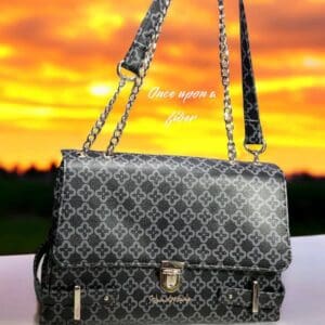Black patterned handbag with chain strap.