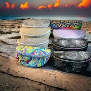 Colorful fanny packs on beach at sunset.